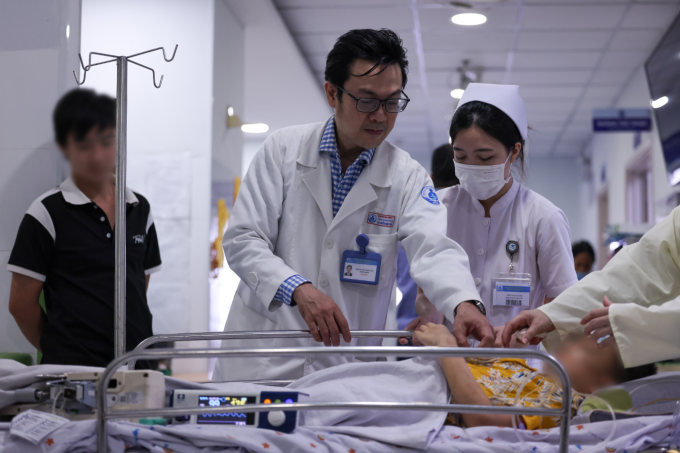 TS.BS Nguyễn Minh Tuấn, Trưởng khoa Sốt xuất huyết - Huyết học, Bệnh viện Nhi đồng 1 thăm khám một bệnh nhi. Ảnh: Ngô Trần Hải An