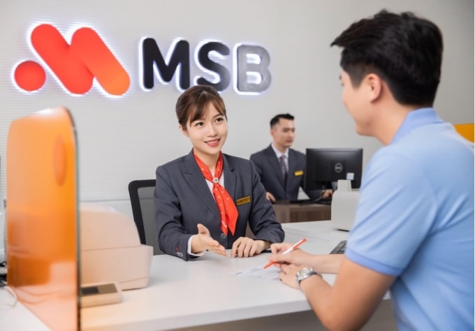 Giao dịch viên hỗ trợ khách hàng làm thủ tục tại quầy. Ảnh: MSB