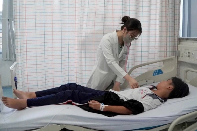 Bác sĩ khám cho một bệnh nhân nghi ngộ độc sau khi ăn bánh mì ở tiệm trên đường Đồ Chiểu. Ảnh: Minh Bằng