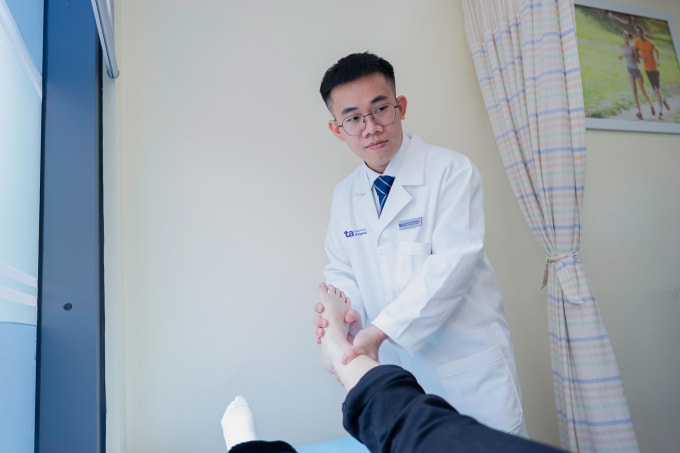 Bác sĩ Thạnh kiểm tra tình trạng chức năng bàn chân người bệnh. Ảnh: Bệnh viện Đa khoa Tâm Anh