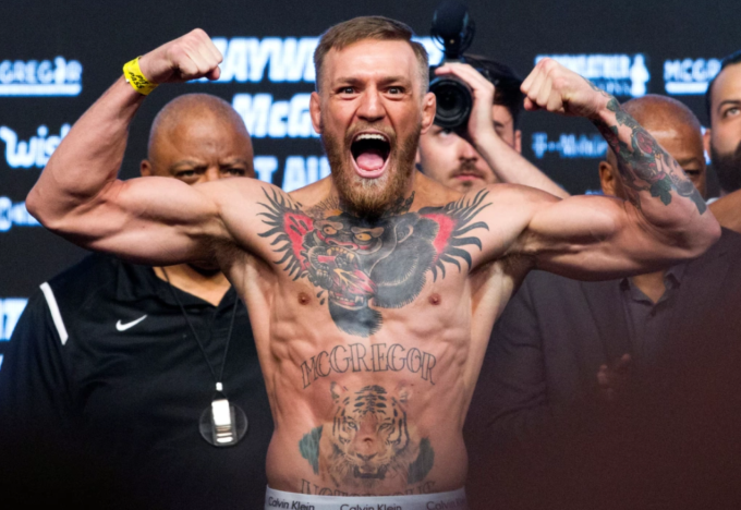 Nhà vô địch hạng nhẹ UFC Conor McGregor tạo dáng trên bàn cân trong buổi cân chính thức tại T-Mobile Arena ở Las Vegas, Nevada, ngày 25/8/2017. Ảnh: Reuters
