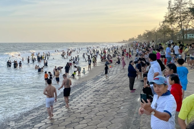 Hàng nghìn du khách từ khắp nơi đổ về biển Đồi Dương - Thương Chánh, Phan Thiết để vui chơi, tắm biển. Bãi biển dài hơn 1 km kín khách, chiều mùng 4 Tết. Ảnh: Việt Quốc