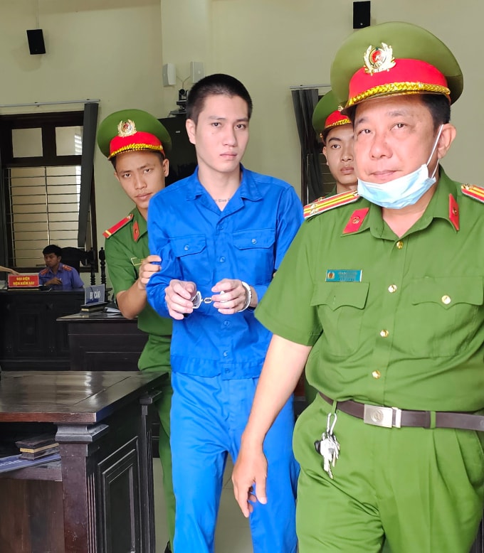 Nguyễn Thành Nhân bị cảnh sát dẫn giải ra xe sau phiên xử. Ảnh: Nam An