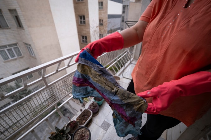 Người Tehran lau vết dầu khỏi ban công sau cơn mưa ngày 8/3. Ảnh: AFP