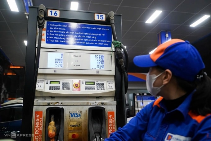 Nhân viên một cửa hàng ở Hà Nội bơm xăng theo bảng giá mới sau 22h ngày 11/3. Ảnh: Hoàng Giang