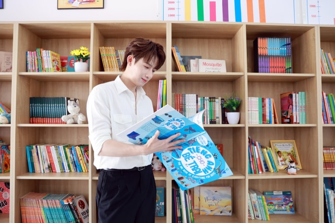 Ca sĩ Hồ Đông Quan đọc sách trong thư viện do VnExpress trao tặng Trường THCS Thanh Sơn, ngày 10/3. Ảnh: Đức Đồng