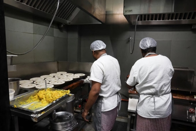 Các nhân viên đang làm bánh dosa bên trong nhà hàng Vidyarthi Bhavan, Ấn Độ. Ảnh: Reuters/Priyanshu Singh