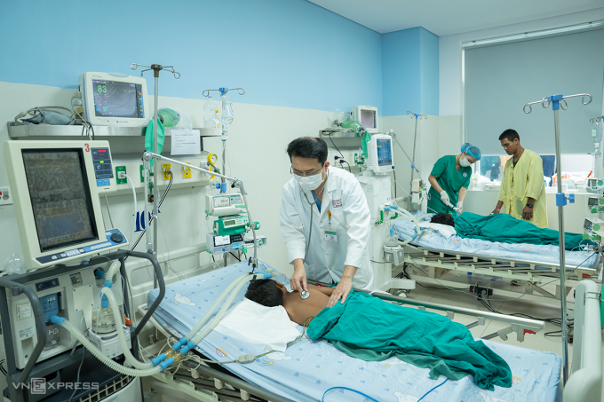 Bác sĩ Trần Long Quân thăm khám cho hai bệnh nhi, sáng 12/3. Ảnh: Nguyễn Đông