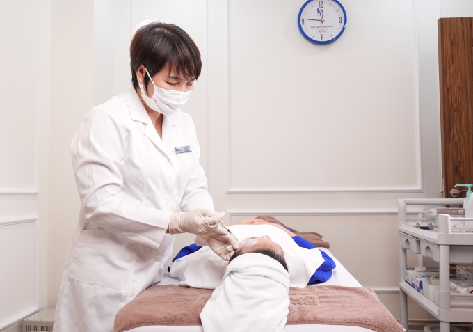 Bác sĩ chuẩn bị thực hiện tiêm botox xóa nhăn trán cho một phụ nữ. Ảnh: Bệnh viện Đa khoa Tâm Anh