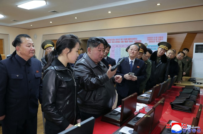 Ông Kim Jong-un cầm súng trong chuyến thăm nhà máy. Ảnh: KCNA