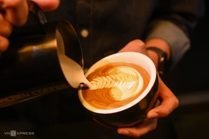 Barista vẽ hình rồng trên ly cà phê espresso. Ảnh: Giang Huy