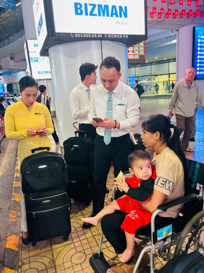 Hai mẹ con chị Nông Thị Hà chờ xe taxi đến đón tại sân bay Nội Bài, Hà Nội, tối 26/2.  Ảnh: Phạm Thu Hà