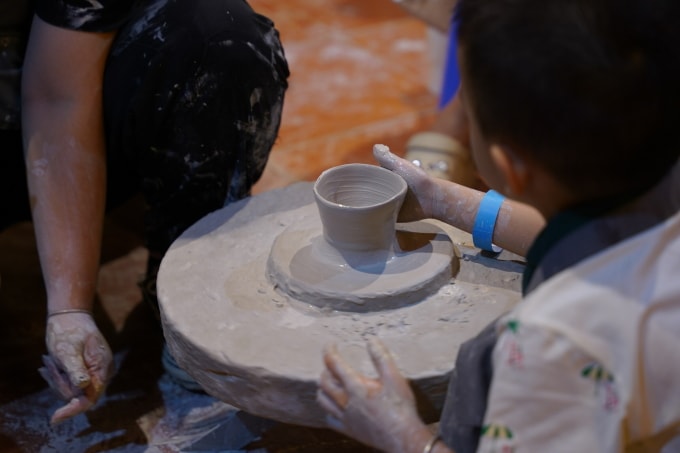 Khách tham quan trải nghiệm làm gốm tại khu tương tác dân gian. Ảnh: Saigontourist Group