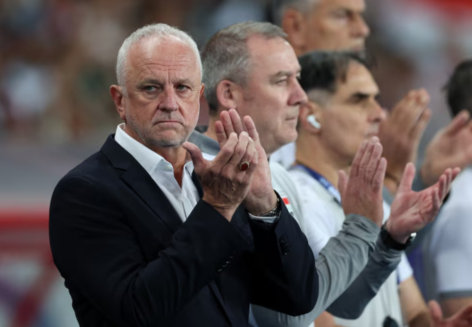 HLV Graham Arnold (áo đen) vỗ tay trước trận Iraq gặp UAE ở vòng loại World Cup 2026 trên sân Basra, Basra, Iraq ngày 18/11/2025. Ảnh: Reuters