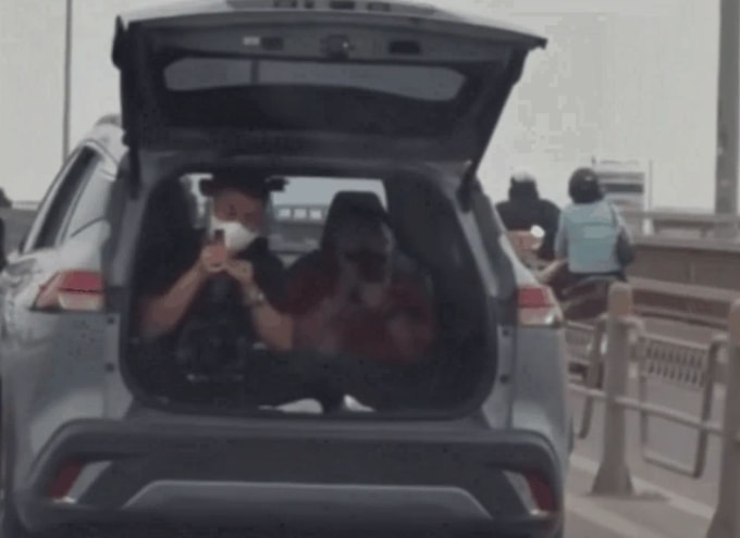 Xe ôtô chở hai người ngồi trong khoang hành lý. Ảnh: Xuân Hoa