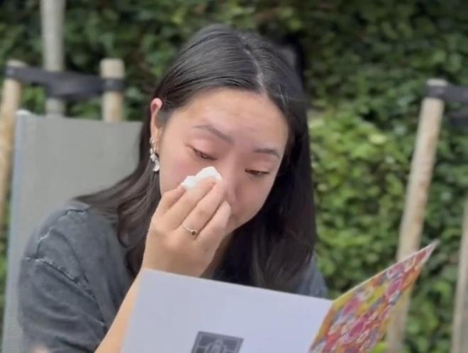 Hong Yangli xúc động khi lần đầu tiên nhìn ảnh cha mẹ ruột. Ảnh: Red Star