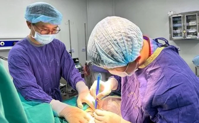 Bác sĩ Tỵ và kíp mổ đang phẫu thuật xử lý khối u vú cho bệnh nhân. Ảnh: Bác sĩ cung cấp