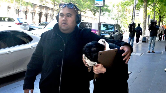 Bao Phuc Cao được hộ tống rời tòa ngày 13/3. Ảnh: Herald Sun