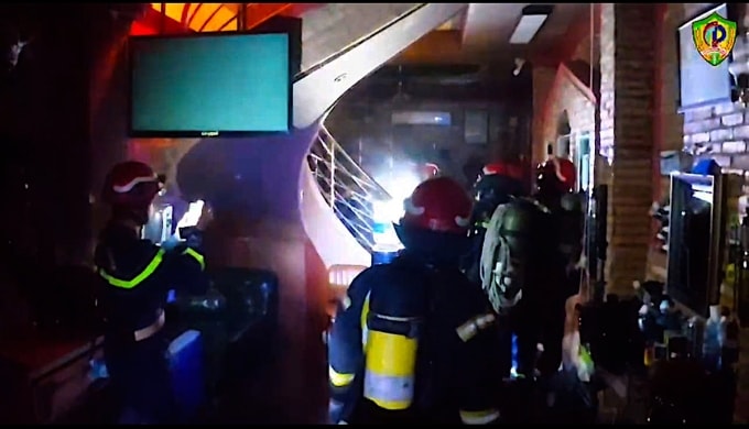 Khói lửa cháy đỏ rực ở lầu một khi lính cứu hoả tiến vào từ tầng trệt để chữa cháy. Ảnh: Minh Nghiêm