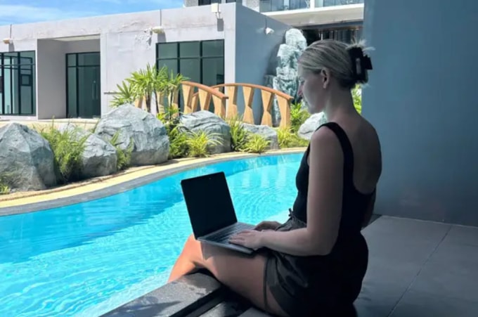 Sally ngồi làm việc tại khu căn hộ thuê tại Bangkok có giá 500 USD một tháng. Ảnh: BI