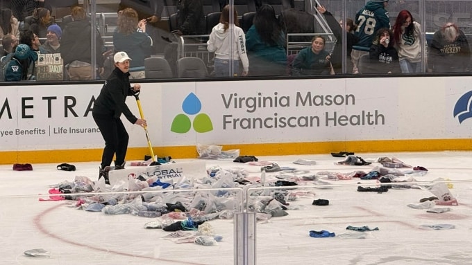 Một nhân viên thu dọn các áo ngực trong trận khúc côn cầu trên băng giữa Seattle Torrent và Boston Fleet ở sân Climate Pledge, thành phố Seattle, bang Washington, Mỹ, tối 11/3/2026. Ảnh: PWHL