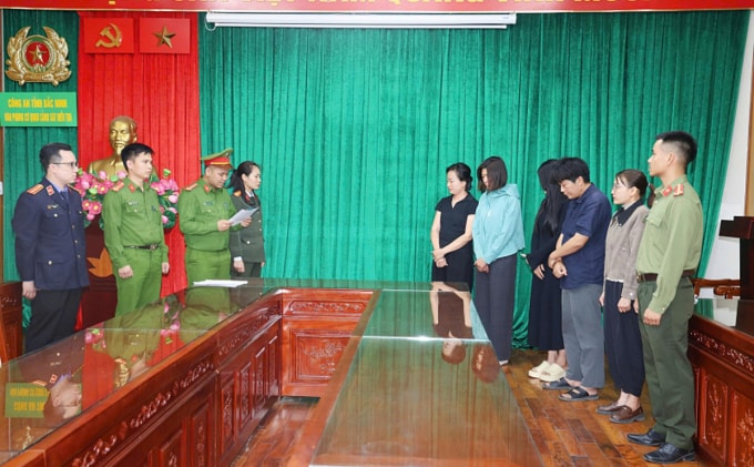 Công an tống đạt quyết định khởi tố với nhóm bị can. Ảnh: Công an cung cấp