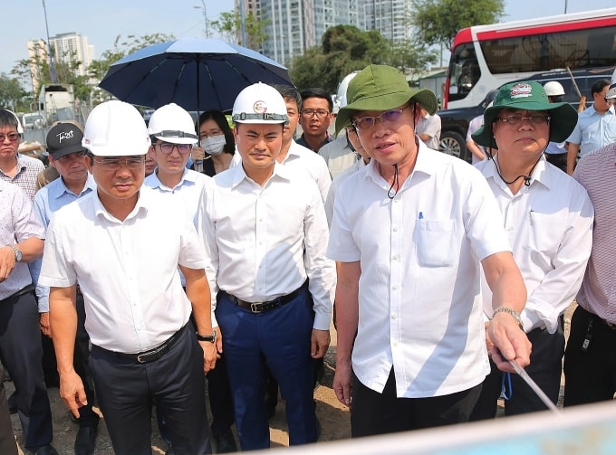 Chủ tịch UBND TP HCM Nguyễn Văn Được (bên trái) nghe báo cáo tình hình thi công nút giao An Phú, chiều 17/3. Ảnh: Giang Anh