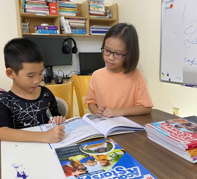 Lê Trần Vân Anh (phải), 9 tuổi, ở phường Nha Trang đang dạy học cho em trai. Ảnh: Nhân vật cung cấp