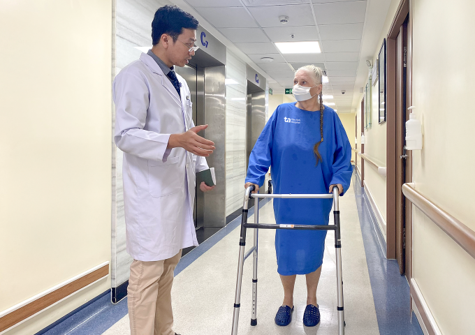 Bác sĩ Khoa Học hướng dẫn bà Victoria tập đi lại trước khi xuất viện. Ảnh: Bệnh viện Đa khoa Tâm Anh