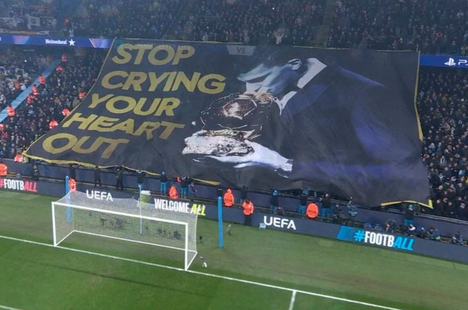 CĐV Man City giương cao biểu ngữ châm chọc Vinicius trên sân Etihad tối 11/2/2025. Ảnh: Sky Sports