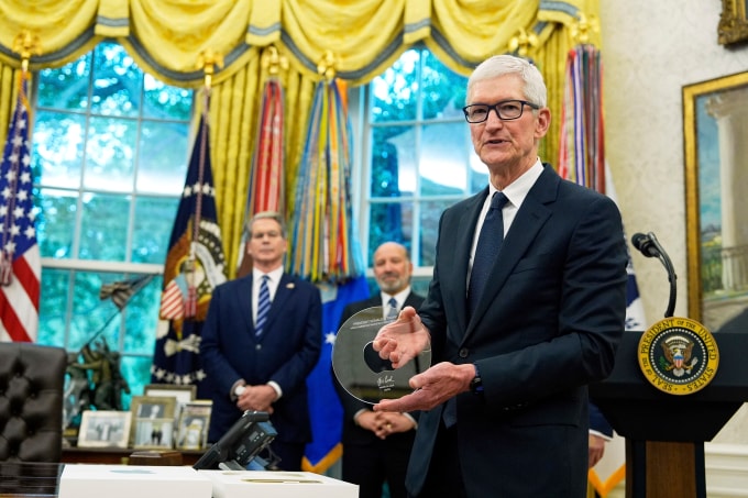 Tim Cook, CEO Apple, cầm món quà từ Tổng thống Mỹ Donald Trump trong một buổi công bố về Apple tại Phòng Bầu dục, Washington, ngày 6/8/2025. Ảnh: AP