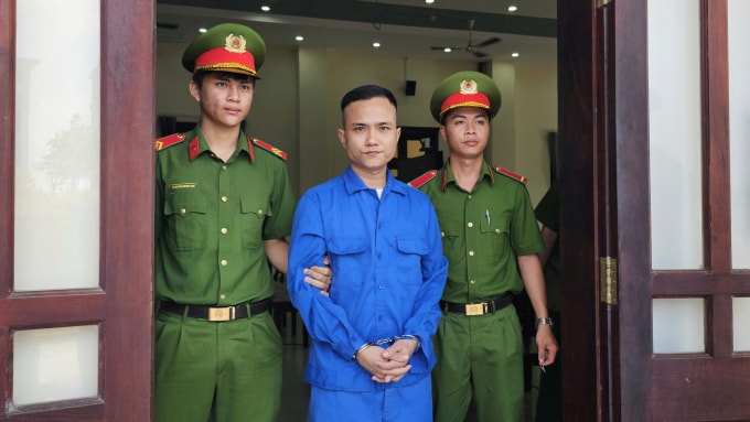 Trương Minh Tân bị áp giải ra xe sau phiên xét xử. Ảnh: Nam An