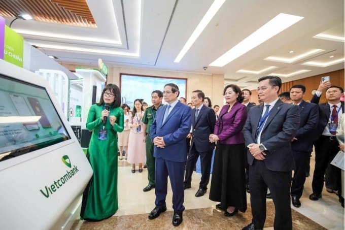 Bà Đoàn Hồng Nhung, Giám đốc Khối bán lẻ Vietcombank giới thiệu với Thủ tướng Chính phủ, Thống đốc NHNN và các đại biểu tính năng đăng ký chữ ký số trên app VCB Digibank thông qua kết nối với Cổng ký số tập trung từ xa VNeID(Năm 2025). Ảnh: Vietcombank