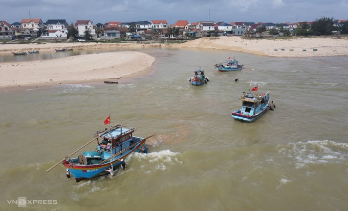 Ngư dân đẩy tàu khi bị mắc cạn. Ảnh: Đắc Thành