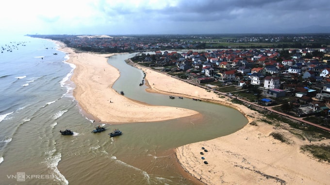 Cửa biển sông Dinh bị cát bồi lấp chỉ còn lạch ở phía bắc, nơi sâu nhất 50 cm. Ảnh: Đắc Thành