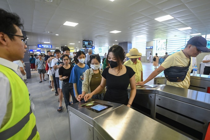 Hành khách qua cổng soát vé tuyến tàu điện Nhổn - ga Hà Nội. Ảnh: Giang Huy