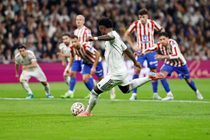 Vinicius sút phạt đền ghi bàn trong trận Real 3-2 Atletico ở vòng 29 La Liga tối 22/3. Ảnh: Reuters
