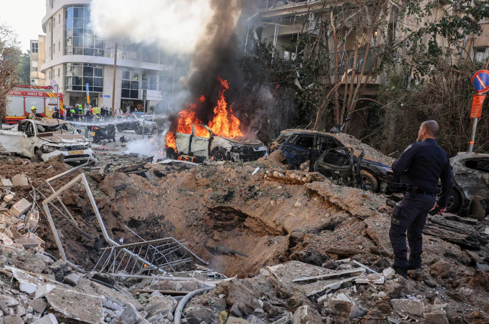 Nhân viên cứu hộ có mặt tại hiện trường sau vụ tấn công tên lửa của Iran ở Tel Aviv. (Ảnh: Reuters)