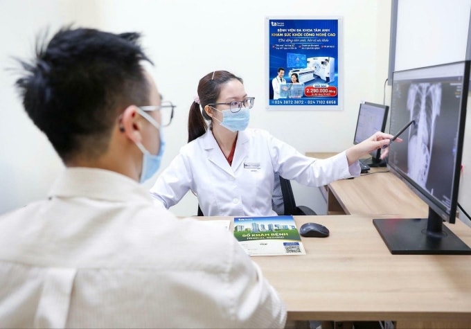 Bác sĩ Thùy giải thích hình ảnh trên phim X-quang cho người đi khám sức khỏe. Ảnh: Bệnh viện Đa khoa Tâm Anh