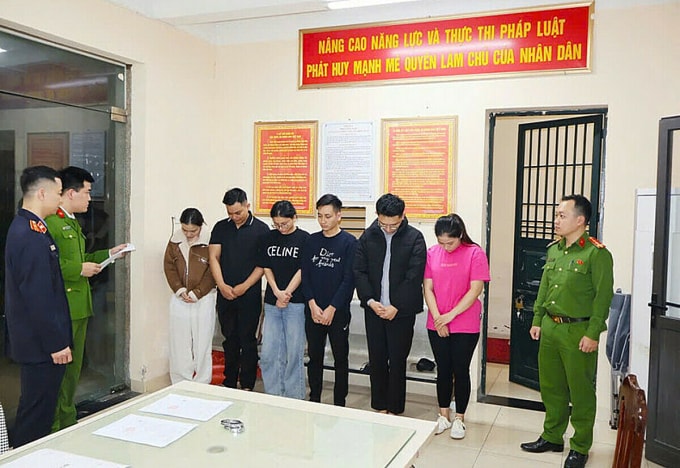 Công an đọc lệnh khởi tố các bị can. Ảnh: Công an cung cấp