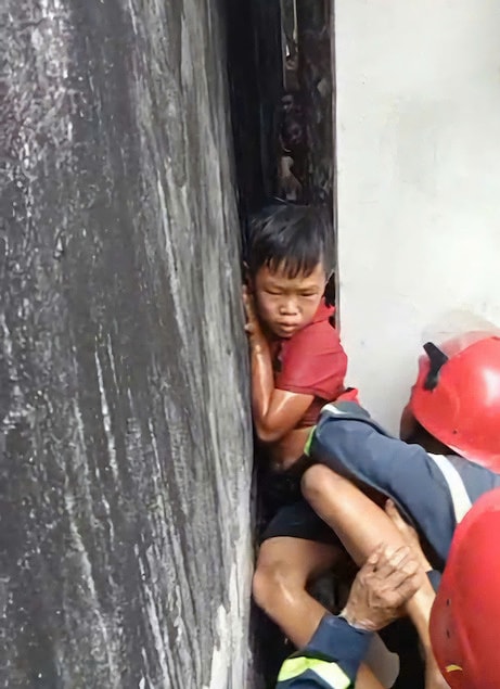 Cảnh sát giải cứu bé trai. Ảnh: Thái Hà
