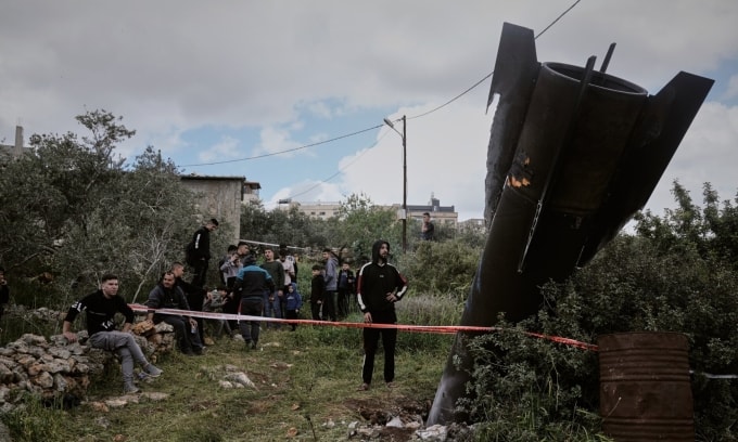 Người dân ở khu vực Bờ Tây, Israel, đứng bên cạnh một mảnh vỡ tên lửa Iran hôm 24/3. Ảnh: AP