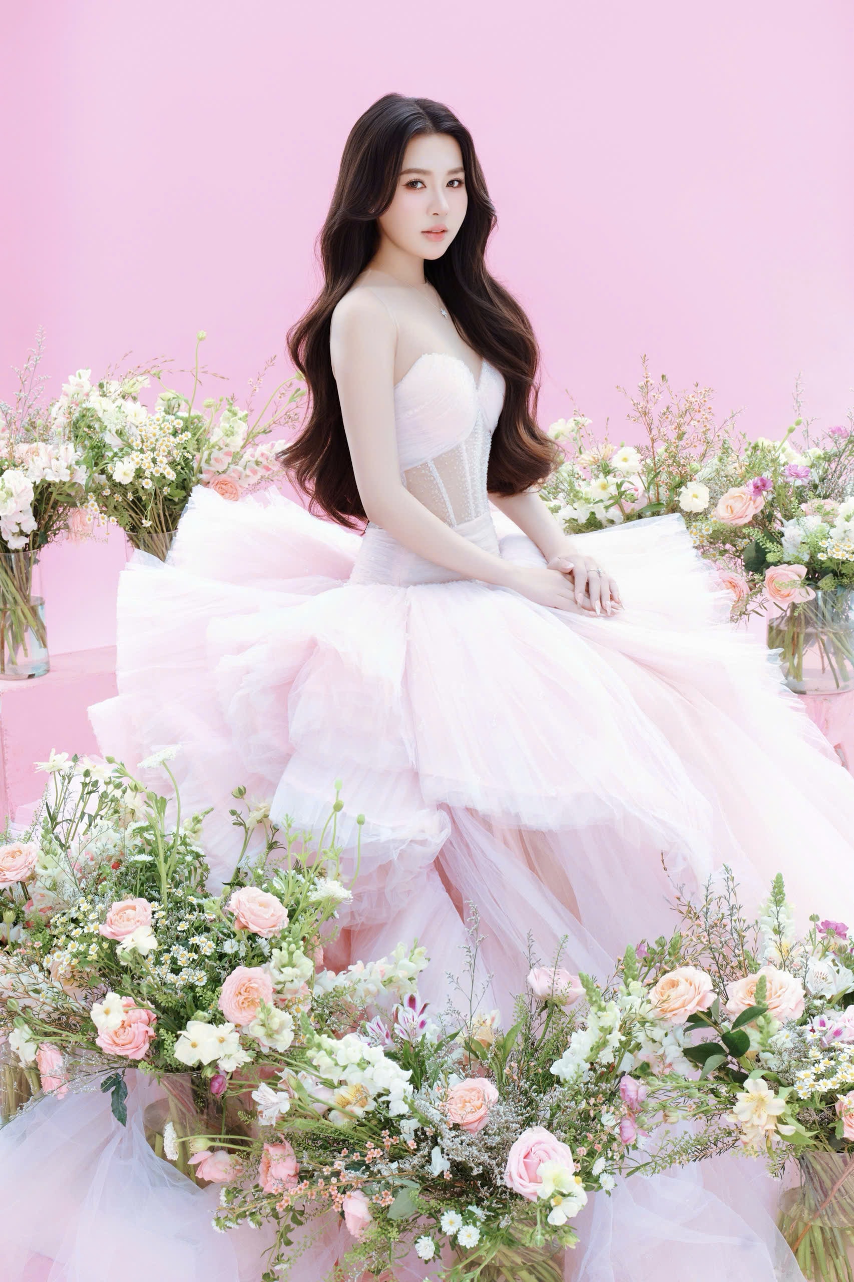 Trong loạt hình, nàng hậu diện những thiết kế váy trắng bồng bềnh, kết hợp cùng không gian được phủ đầy hoa tươi và tông màu pastel chủ đạo như hồng phấn, xanh baby.