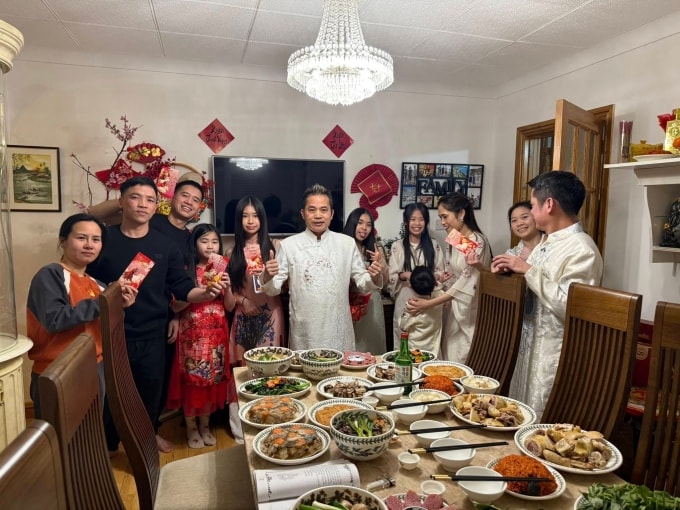 Anh Lê Văn Vinh (áo trắng đứng giữa) cùng các thành viên trong gia đình quây quần bên mâm cơm đầu năm mới trong dịp Tết Nguyên đán 2026 tại thành phố Gloucester, Anh. Ảnh: Nhân vật cung cấp