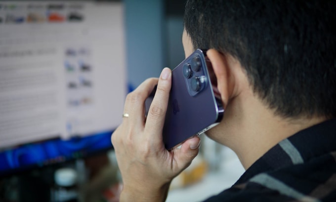 Một người áp điện thoại vào tai khi thực hiện cuộc gọi. Ảnh: Lưu Quý