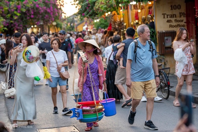 Một gánh hàng rong giữa dòng du khách trên phố cổ Hội An, chiều 25/3. Ảnh: Nguyễn Đông