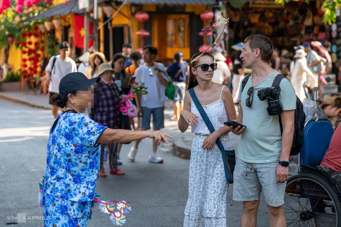 Một người bán hàng rong có hành vi chèo kéo, phóng con chim tre ngay trước mặt du khách. Theo phản ánh, tình trạng phóng chim tre đã nhiều lần lao trúng du khách. Ảnh: Nguyễn Đông