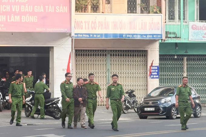 Cảnh sát dẫn ông Tám rời khỏi trụ sở. Ảnh: Hoài Thanh