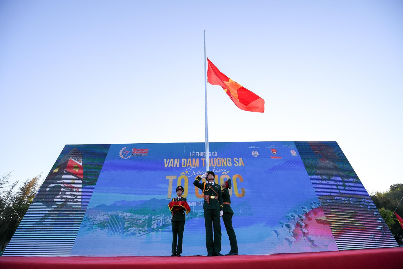 Khi lá cờ được kéo lên, hình ảnh lễ chào cờ của quân và dân tại Trường Sa được truyền về màn hình trung tâm.