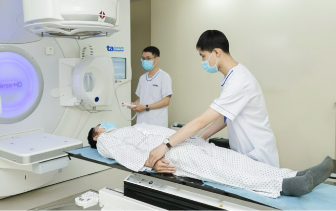 Kỹ thuật viên chuẩn bị, điều chỉnh tư thế nằm đúng cho người bệnh trước xạ trị. Ảnh: Bệnh viện Đa khoa Tâm Anh